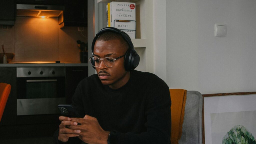 a man sitting in a chair looking at his cell phone