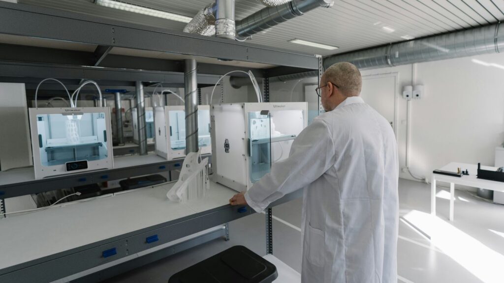man in white laboratory gown standing near white and black machine