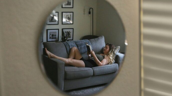 A woman laying on a couch reading a book