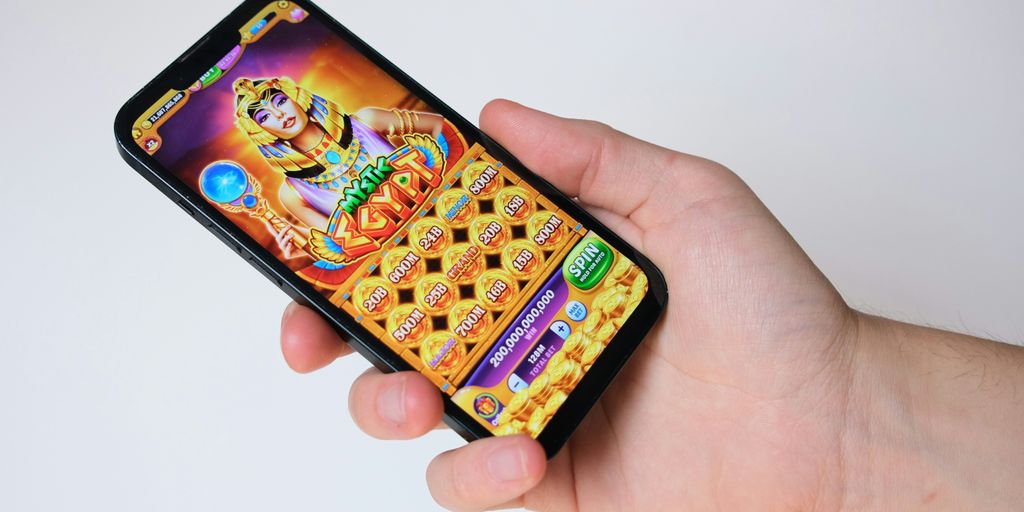 A hand holds a phone with an egyptian-themed game.