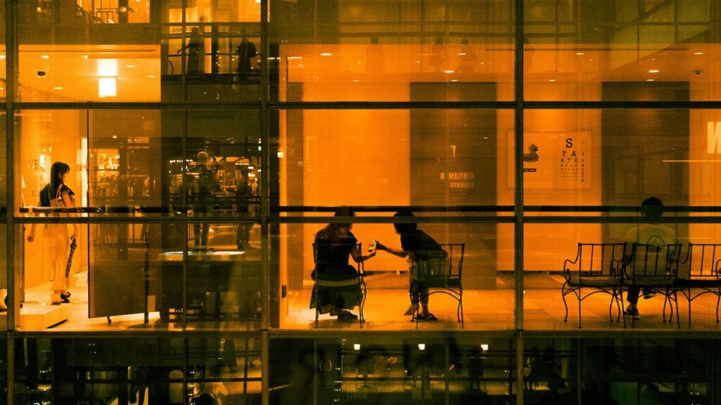 a reflection of a man and woman in a glass room