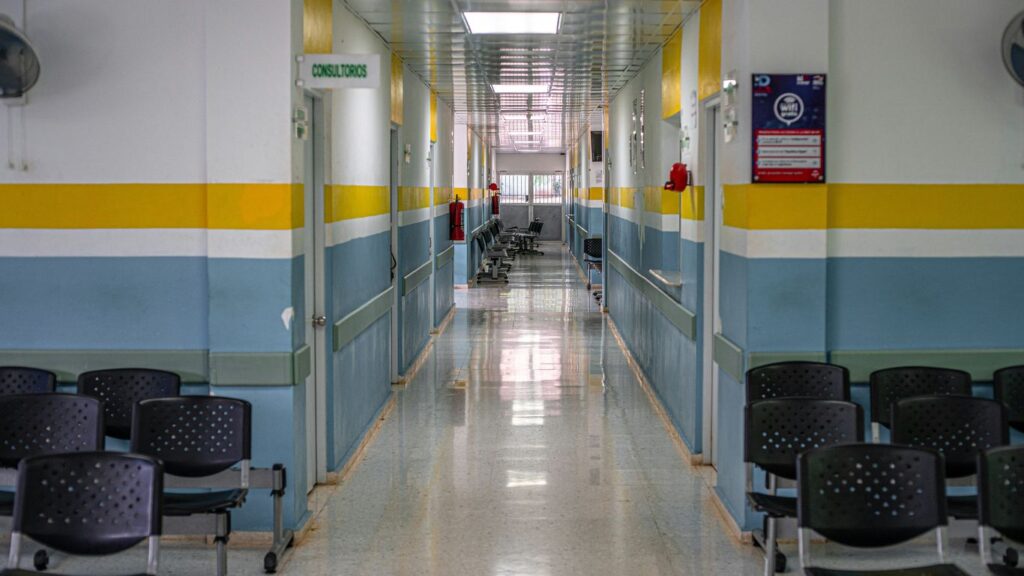 A long hallway with chairs and a clock on the wall