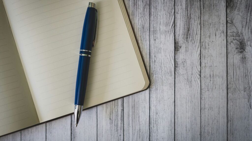 blue click pen on brown wooden table