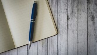 blue click pen on brown wooden table