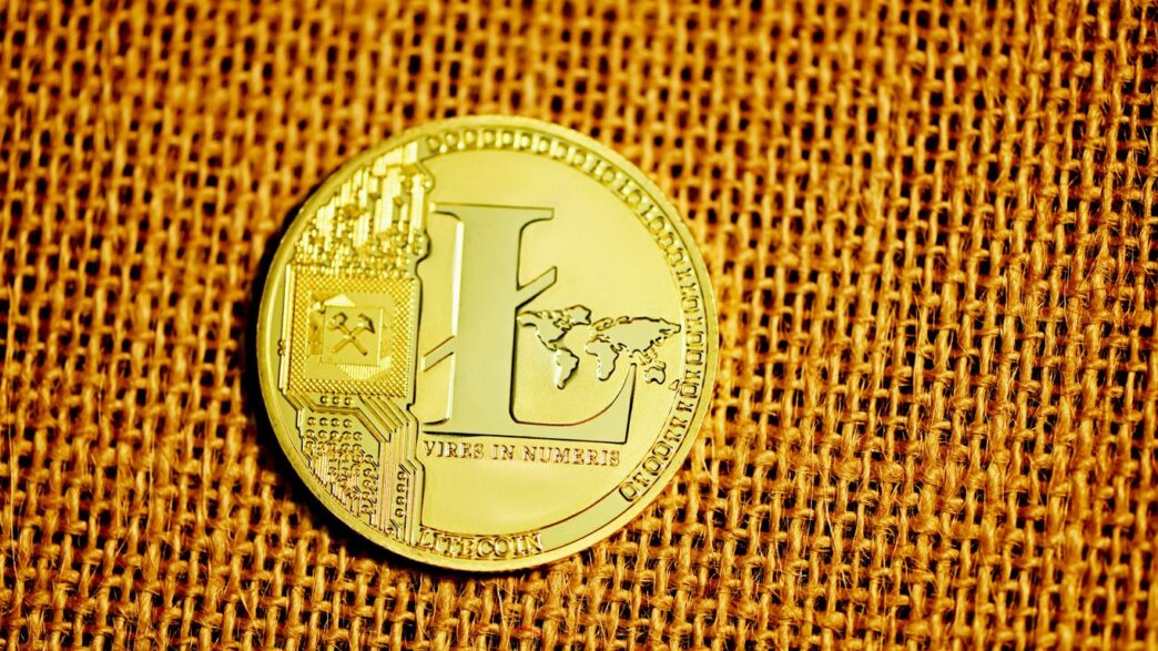silver round coin on brown textile