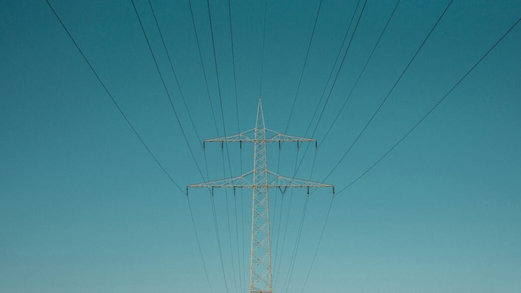 white electric post under blue sky during daytime