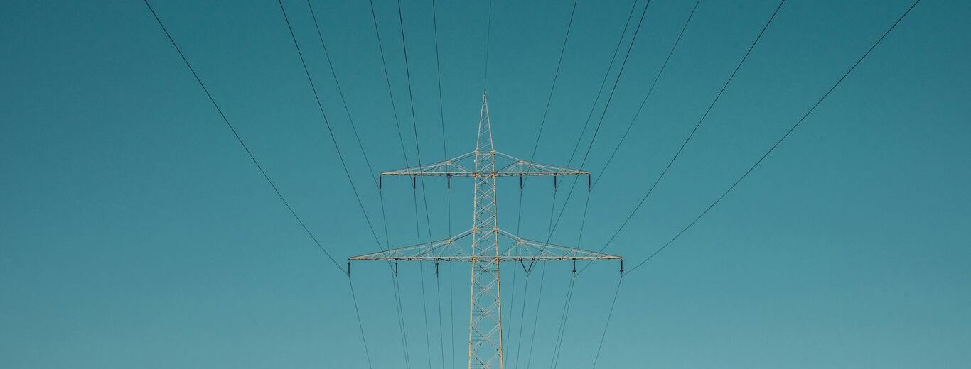 white electric post under blue sky during daytime