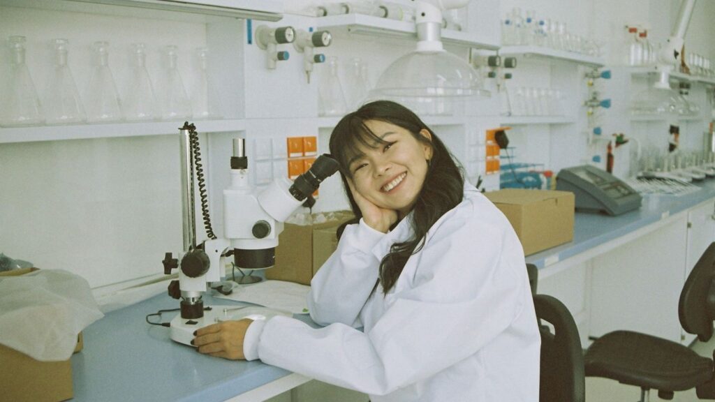 woman in white laboratory gown holding black microphone