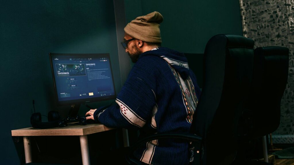 a man sitting in front of a computer monitor