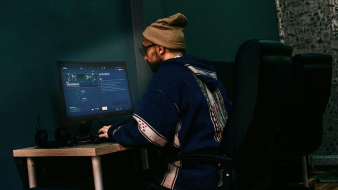 a man sitting in front of a computer monitor