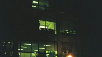 a building lit up at night with a street light in front of it