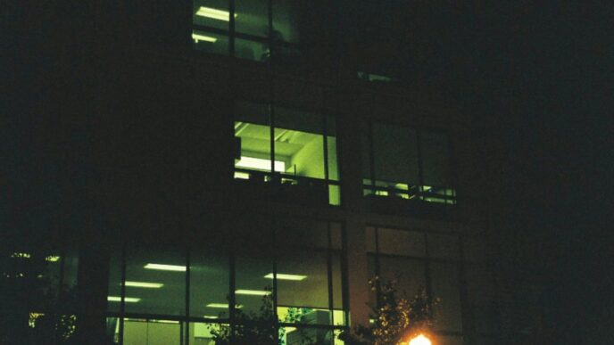 a building lit up at night with a street light in front of it