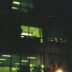 a building lit up at night with a street light in front of it