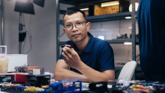 Man in glasses sitting at a desk with items