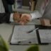 two people shaking hands over a piece of paper