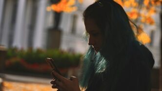 woman in black long sleeve shirt holding smartphone
