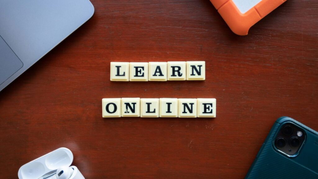 a wooden table with scrabble tiles spelling learn online