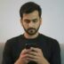 Man in black shirt looking at smartphone