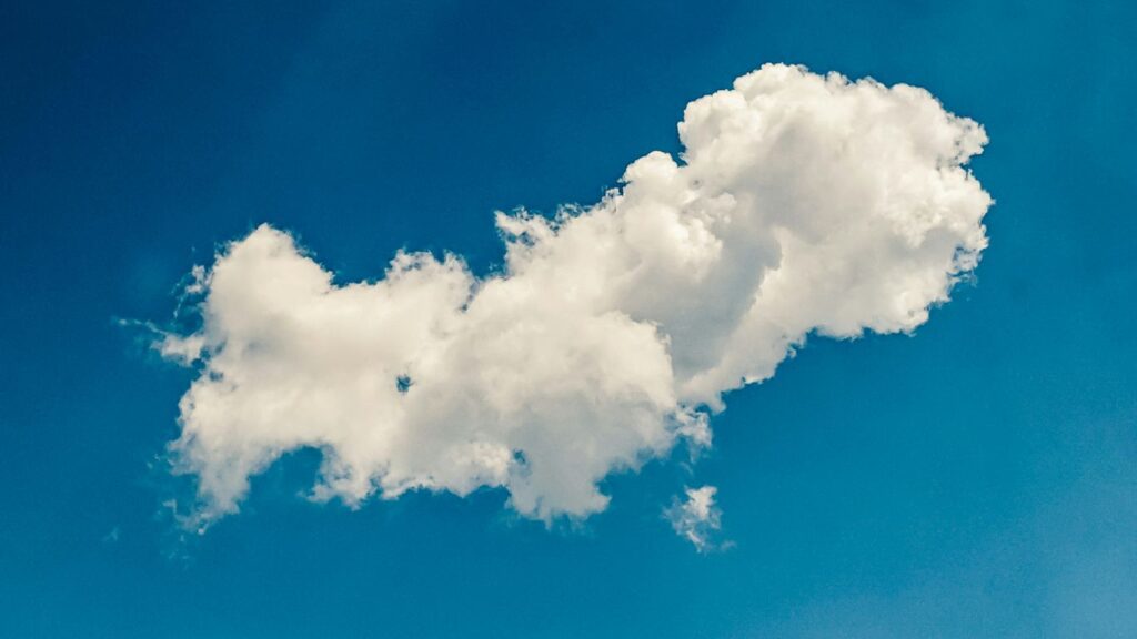a white cloud floating in a blue sky