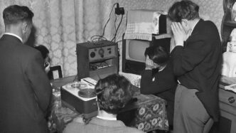 a black and white photo of people in a living room