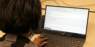 a person sitting in front of a laptop computer