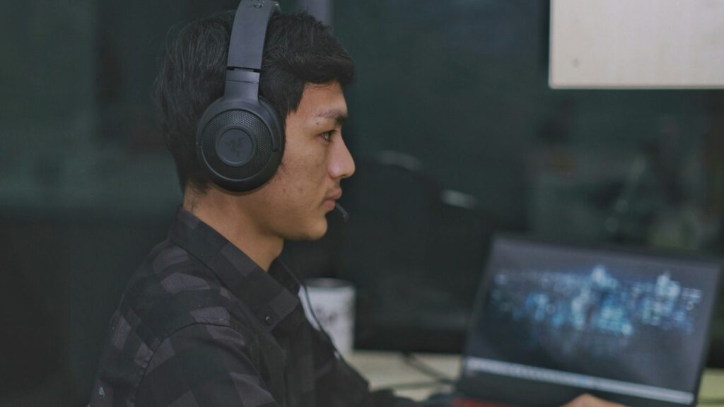 a man wearing headphones is using a laptop