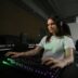 A woman sitting at a desk with a keyboard and mouse