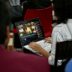 A group of people sitting around a table with laptops