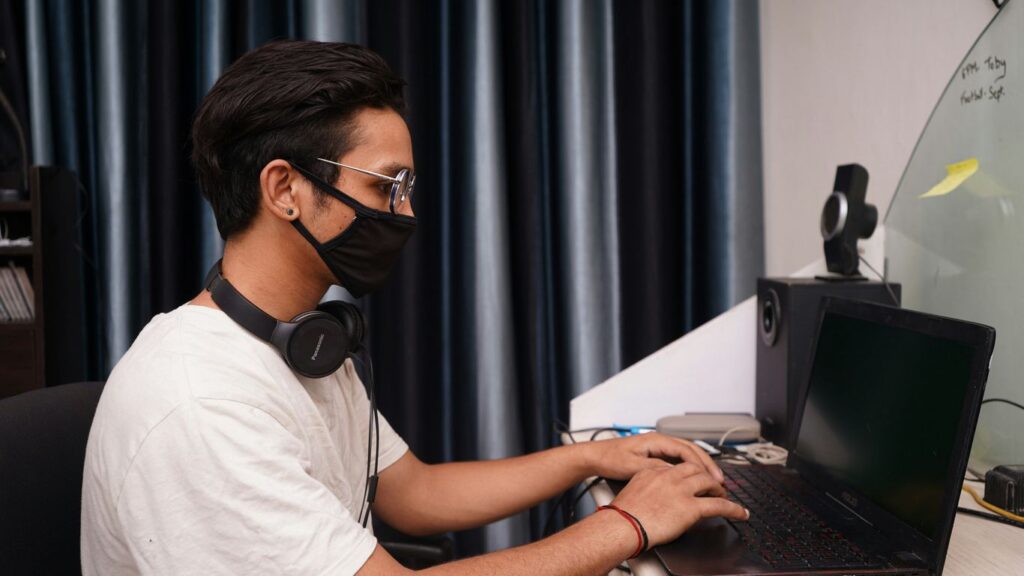 man in white crew neck t-shirt using black laptop computer