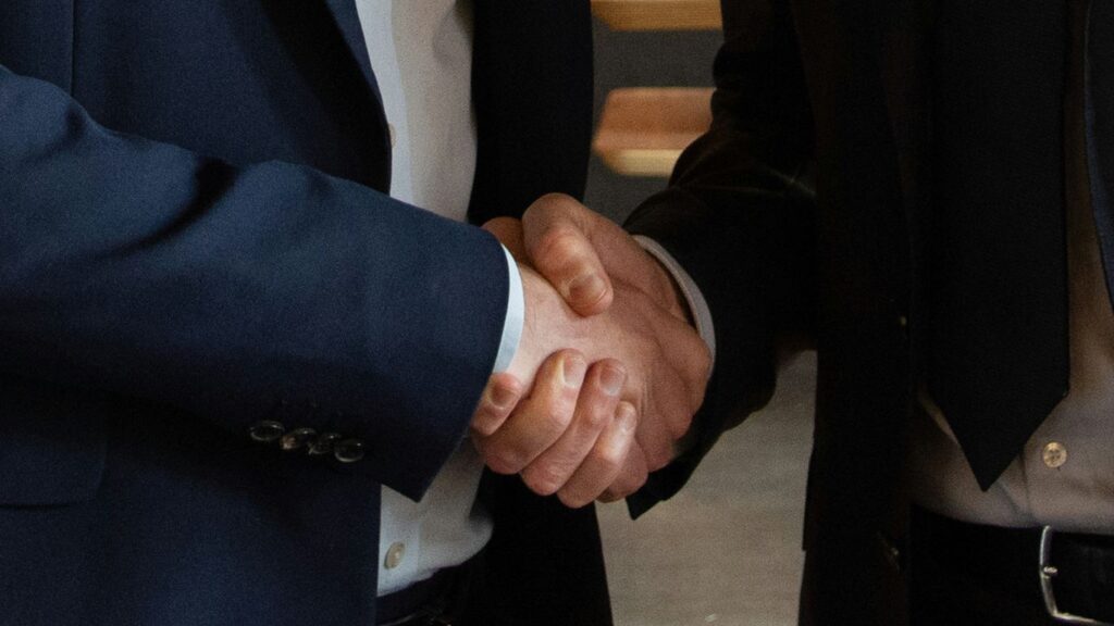 Business partners shake hands, making a deal.