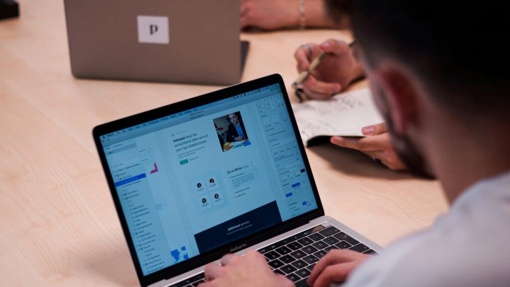 person using macbook pro on table