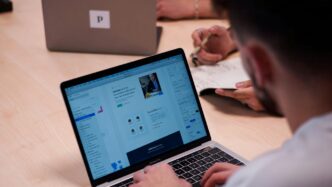 person using macbook pro on table