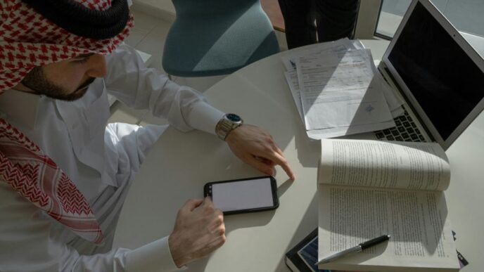 a man sitting at a table looking at a tablet