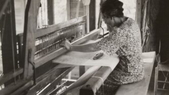 sitting woman using weaving machine