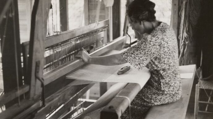 sitting woman using weaving machine