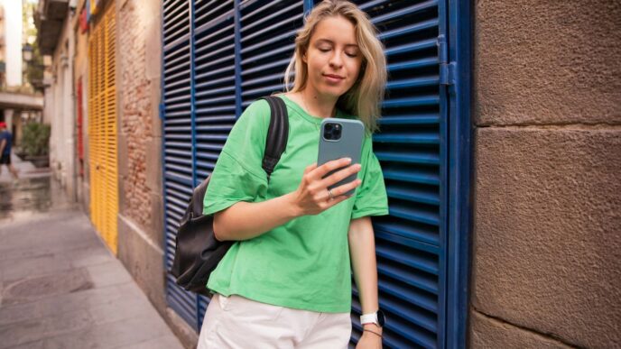 a woman in a green shirt is looking at her cell phone