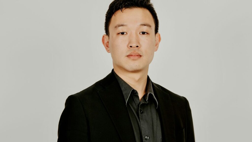 A man in a black suit and black shirt