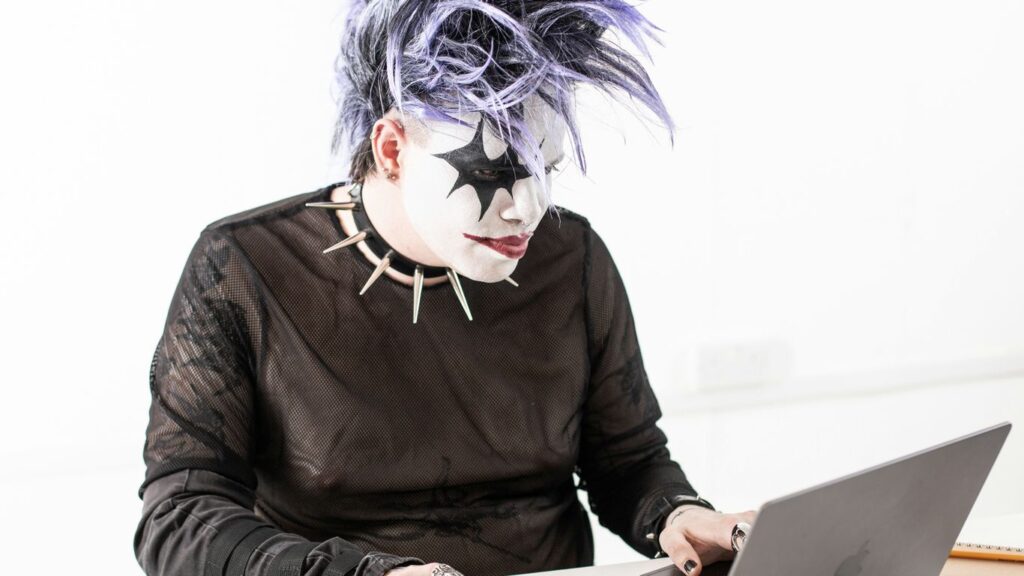a person in a mask using a laptop