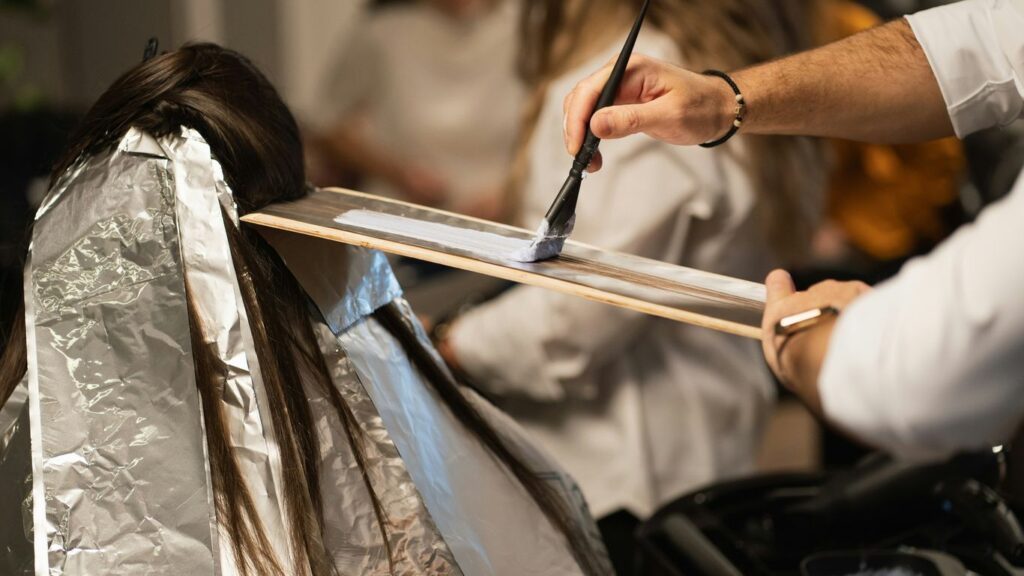 a man cutting a woman's hair with a pair of scissors