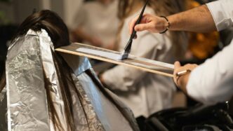 a man cutting a woman's hair with a pair of scissors