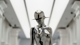 A futuristic silver sculpture stands.