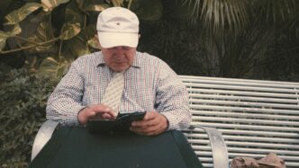 a man sitting on a bench looking at his cell phone