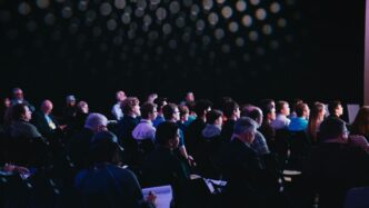 crowd of people sitting on chairs inside room