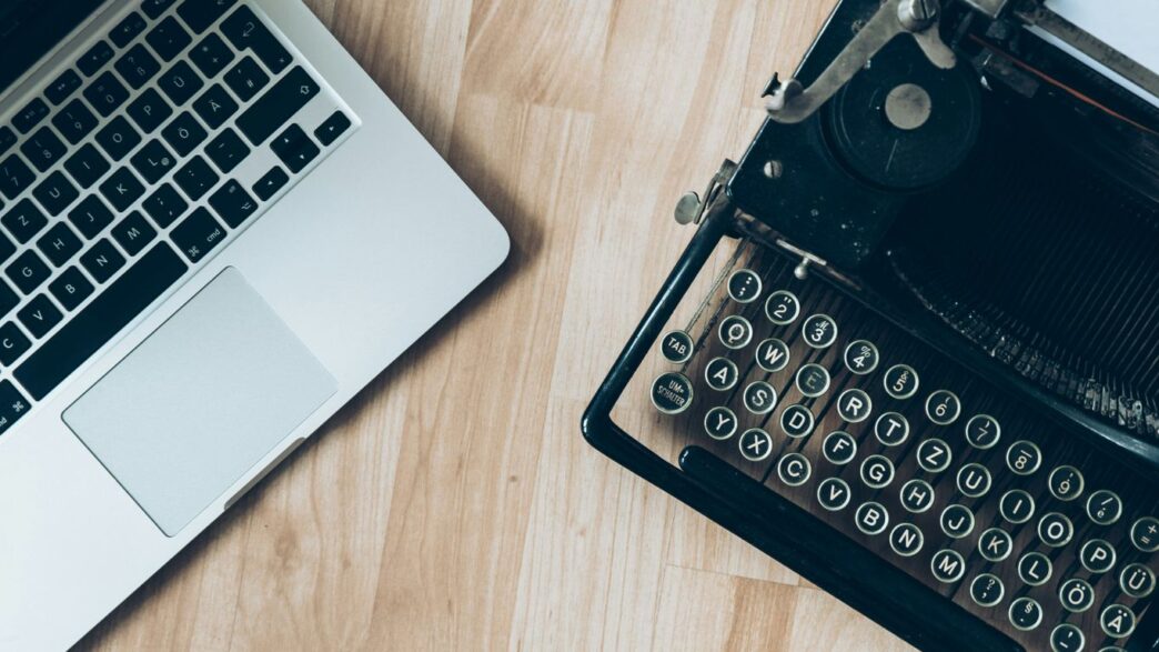 MacBook beside typewriter machine