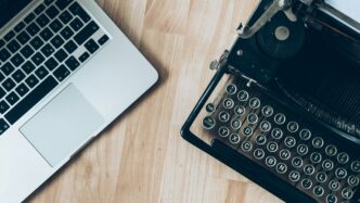 MacBook beside typewriter machine