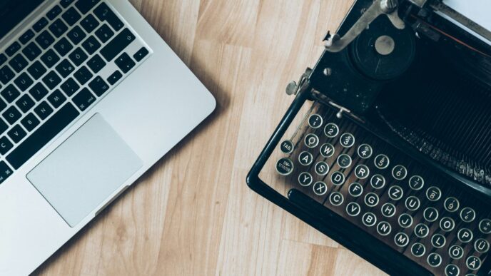 MacBook beside typewriter machine