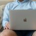 a man sitting on a couch holding a laptop