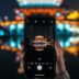 person holding iphone taking photo of yellow and white tower