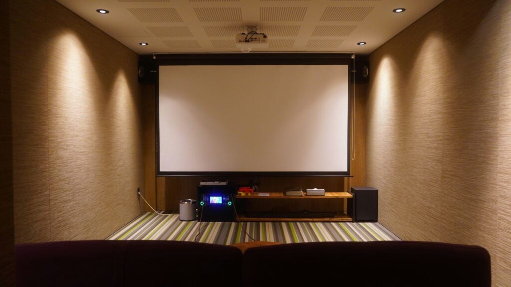 Home theater with a screen and comfortable seating.