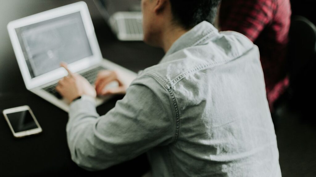 a man sitting at a table using a laptop computer
